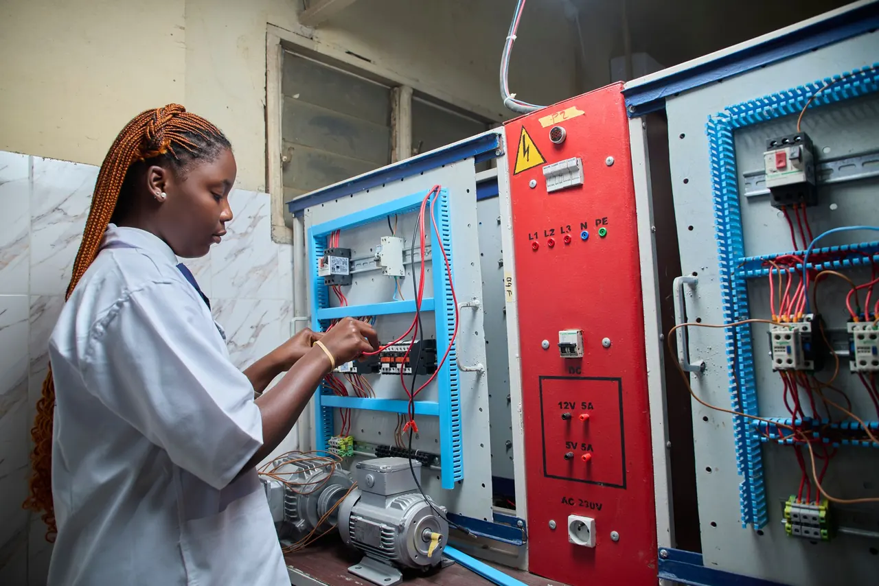A technician wiring an industrial electrical control panel