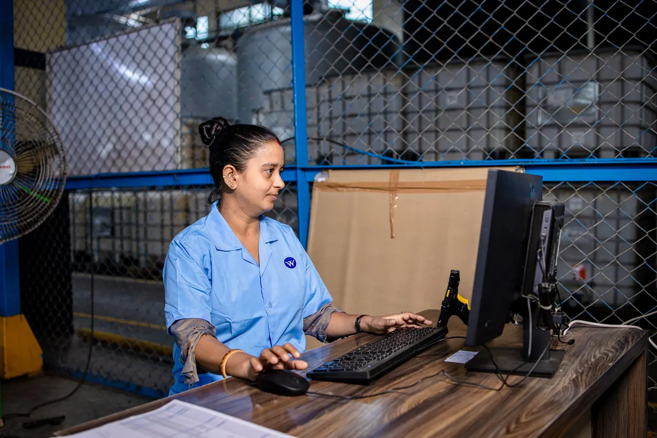 A production worker entering data at a computer on the shop floor